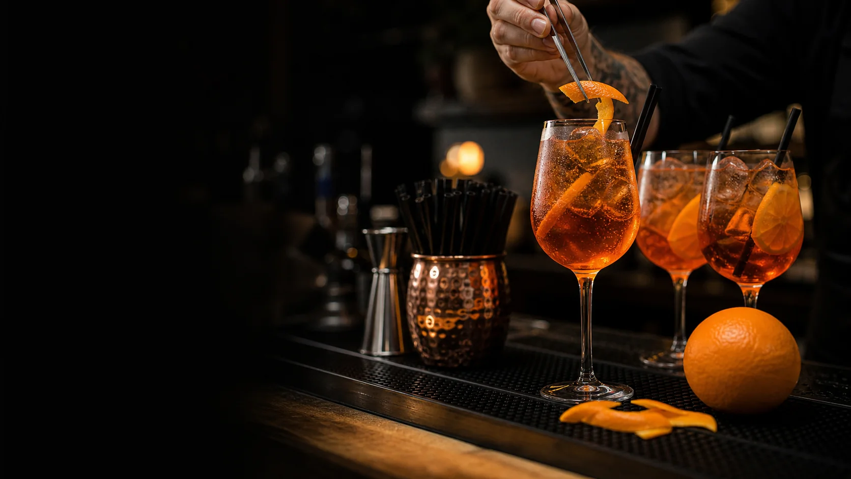 Bartender garnishing orange spritz cocktails at the HOPS bar
