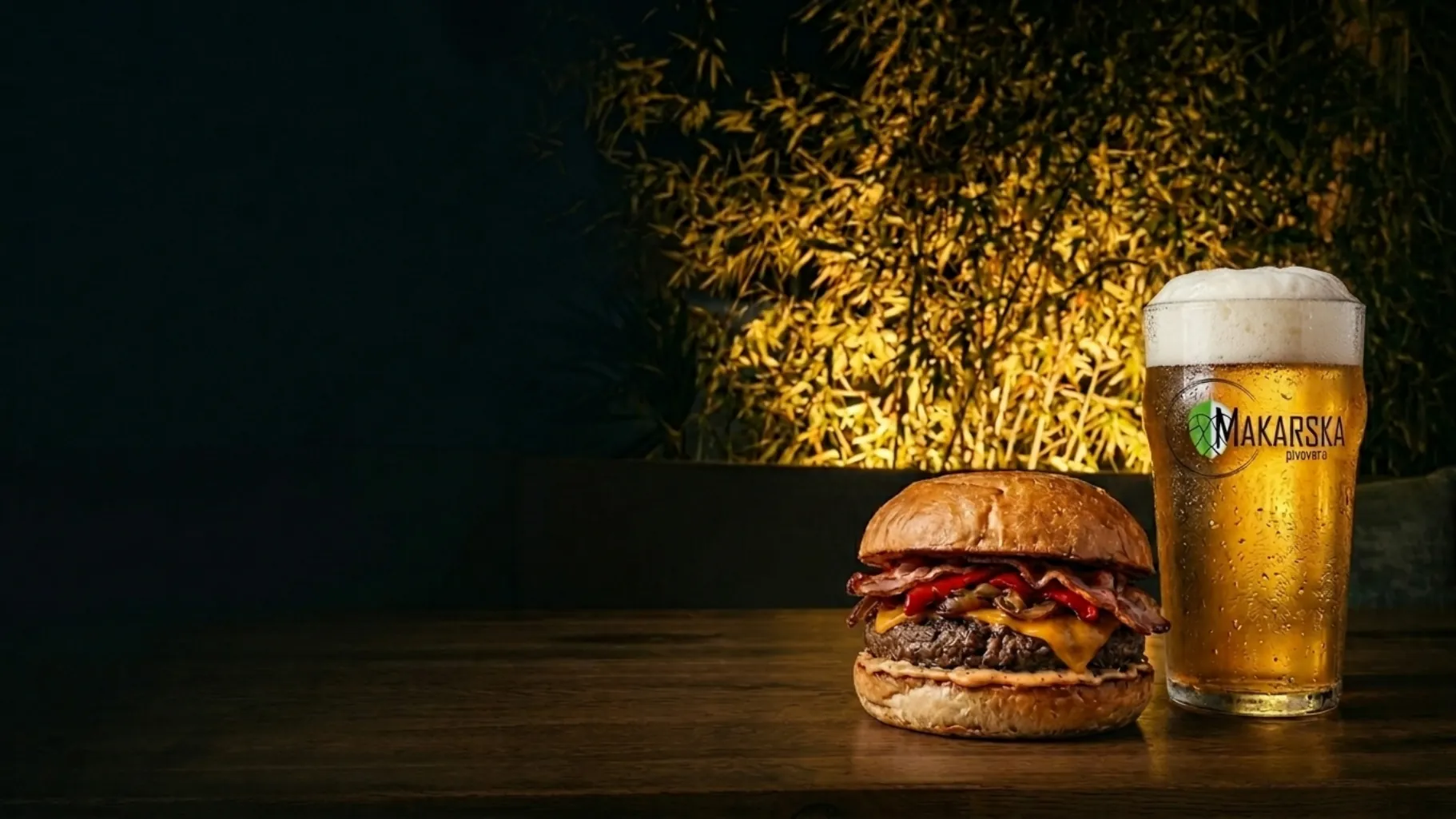 Burger and Makarska Pivovara beer on a dark terrace table